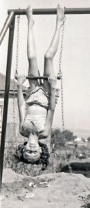 Joan, as a child, hanging on a swingset