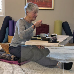 Joyce sitting on cushion on floor for meal time