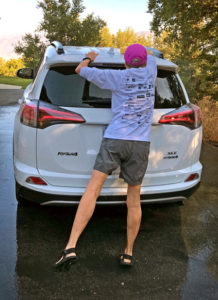 Joan on tippy toe to wash top of car